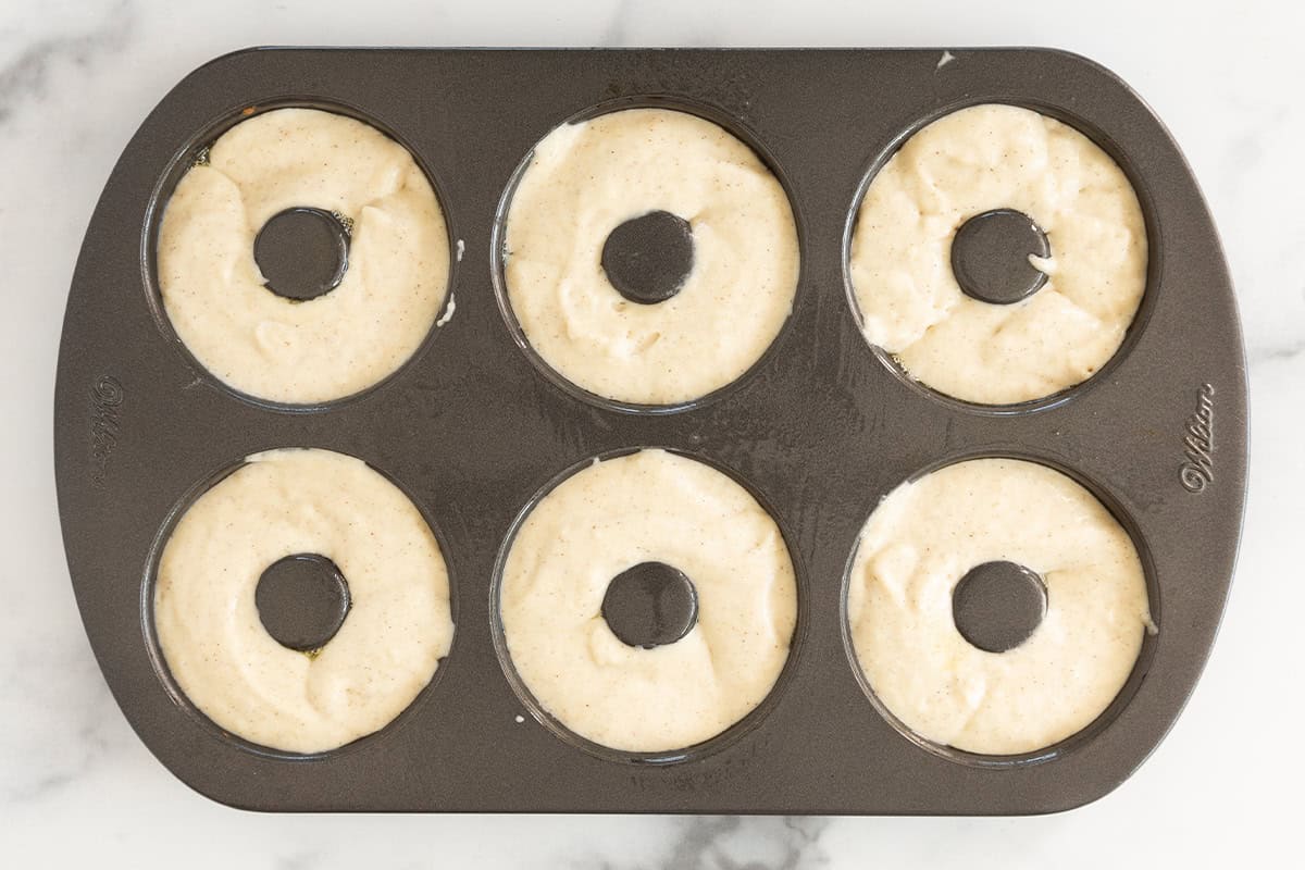 Baked donuts in donut pan before baking.