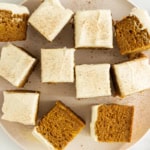 Squares of pumpkin cake on white plate.