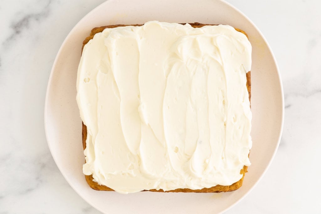 Pumpkin cake with cream cheese frosting on top.