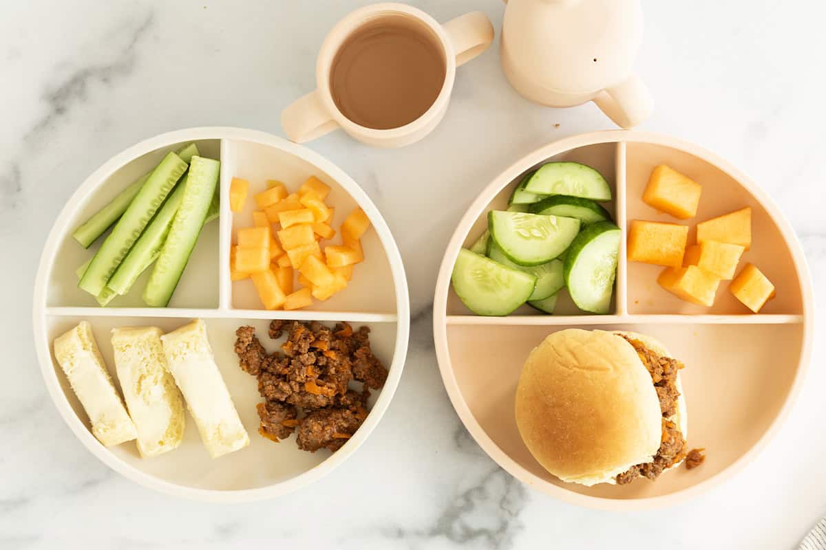 Sloppy joes on two plates with sides.