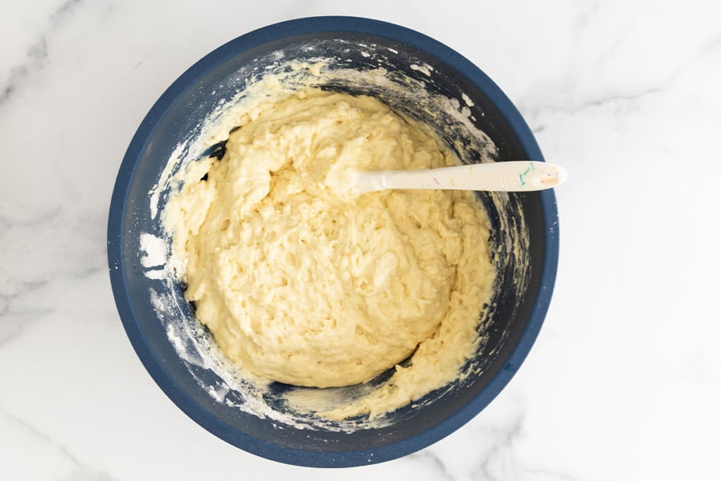 Batter for greek yogurt cake in blue bowl.