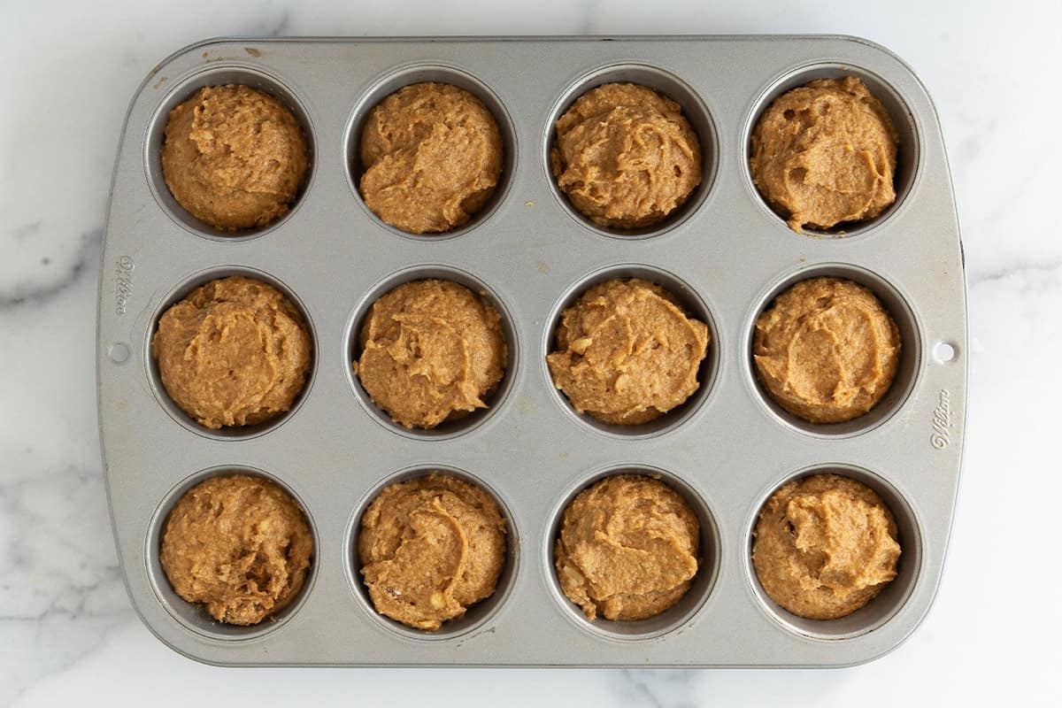 Pumpkin banana muffins in muffin pan before baking.