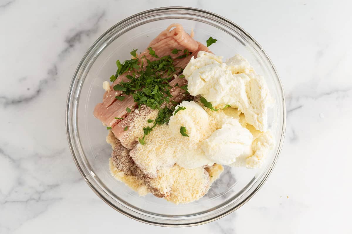 Ingredients for ricotta meatballs in bowl before mixing.