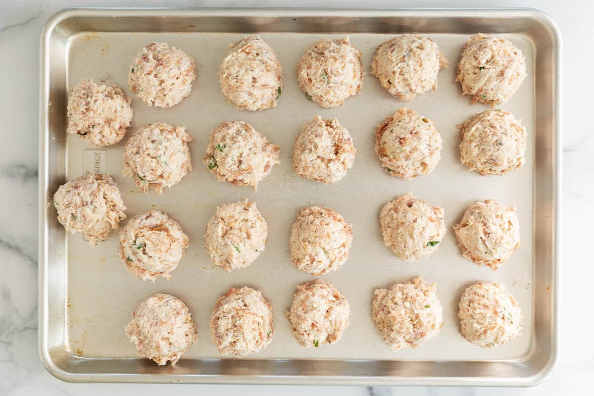 Ricotta meatballs on cooking sheet before baking.