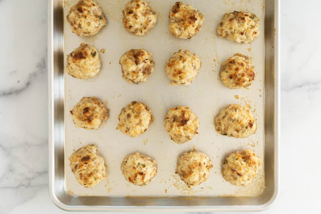 Ricotta meatballs on cooking sheet after baking.