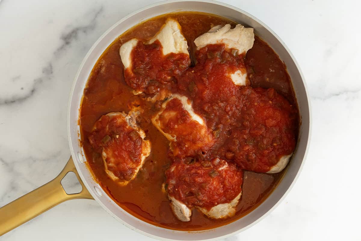 Chicken and salsa cooked in frying pan for chicken tacos.