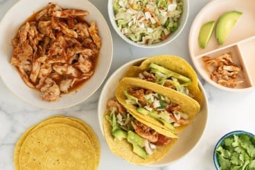 Salsa chicken tacos on various plates with sides.