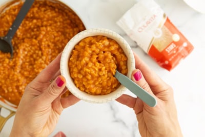 Hands holding bowl of pastina soup.