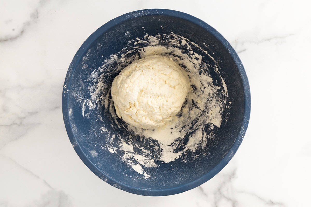 Dough for bagels in blue bowl.