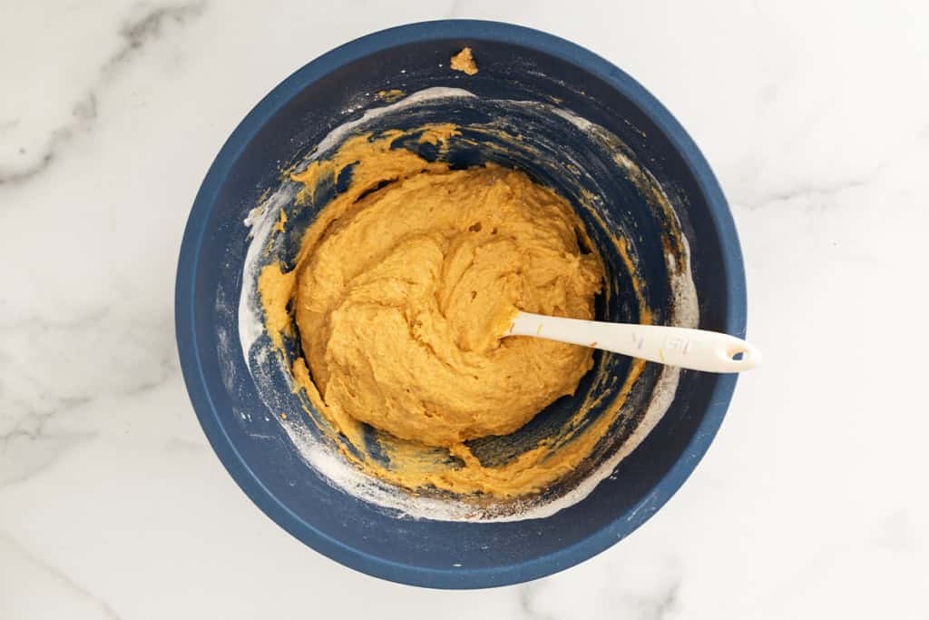 Batter for baked pumpkin donuts in blue bowl.