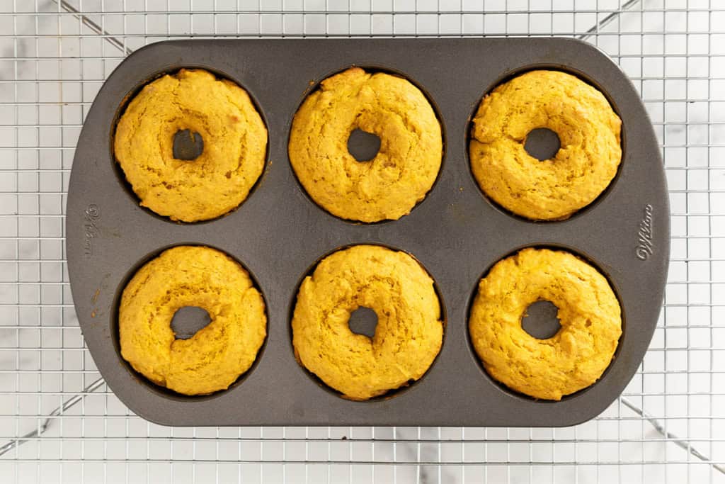 Pumpkin donuts in donut pan after baking.