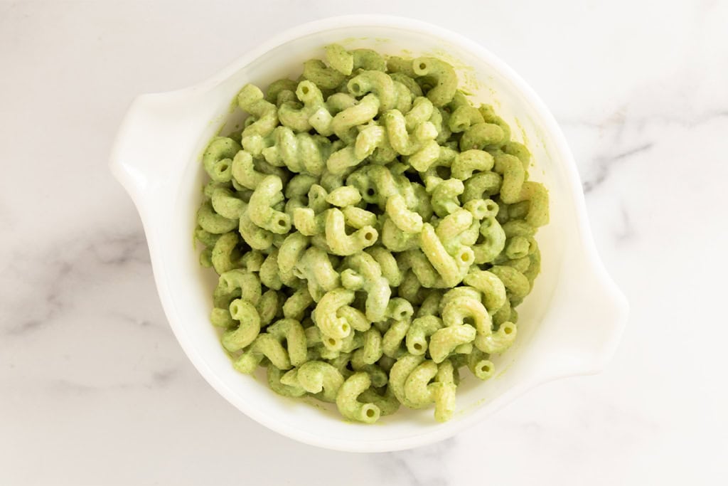 Green pasta in white bowl for halloween pasta.