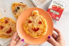 Halloween pizza on orange plate.