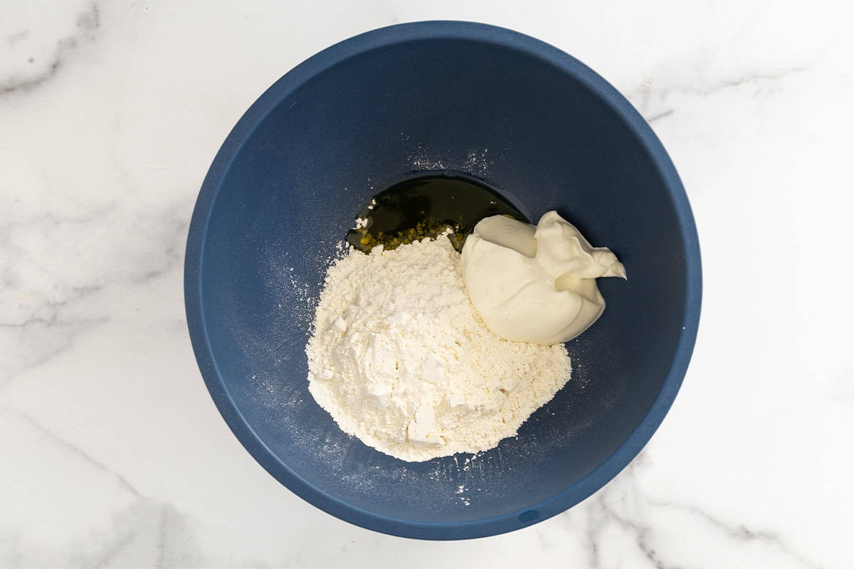 Ingredients for halloween pizza dough in blue bowl.