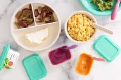 little spoon products and toddler food on plates on counter.