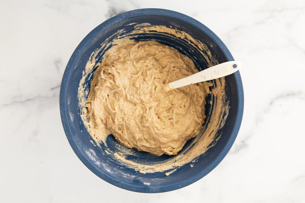 Batter for pear muffins in blue bowl.