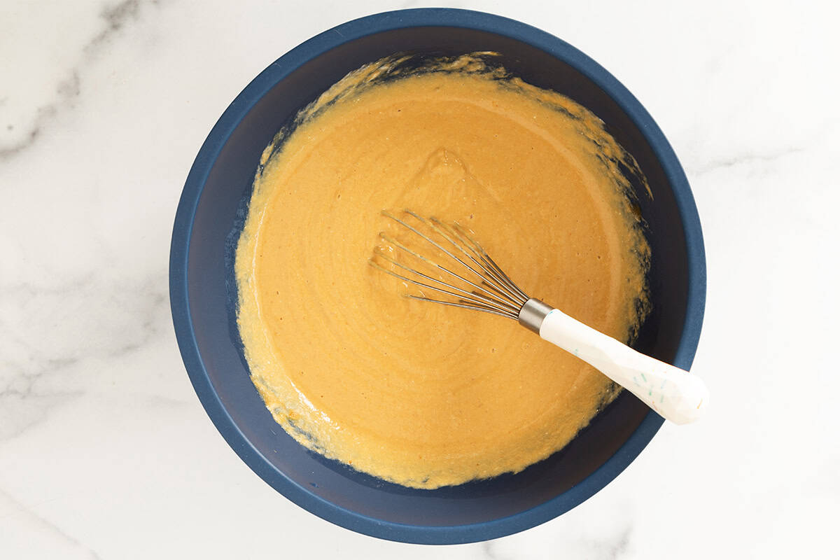 Wet ingredients for pumpkin protein muffins in blue bowl.