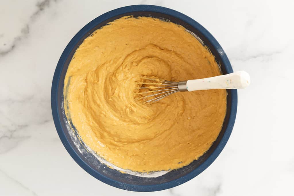 Batter for pumpkin protein muffins in blue bowl.