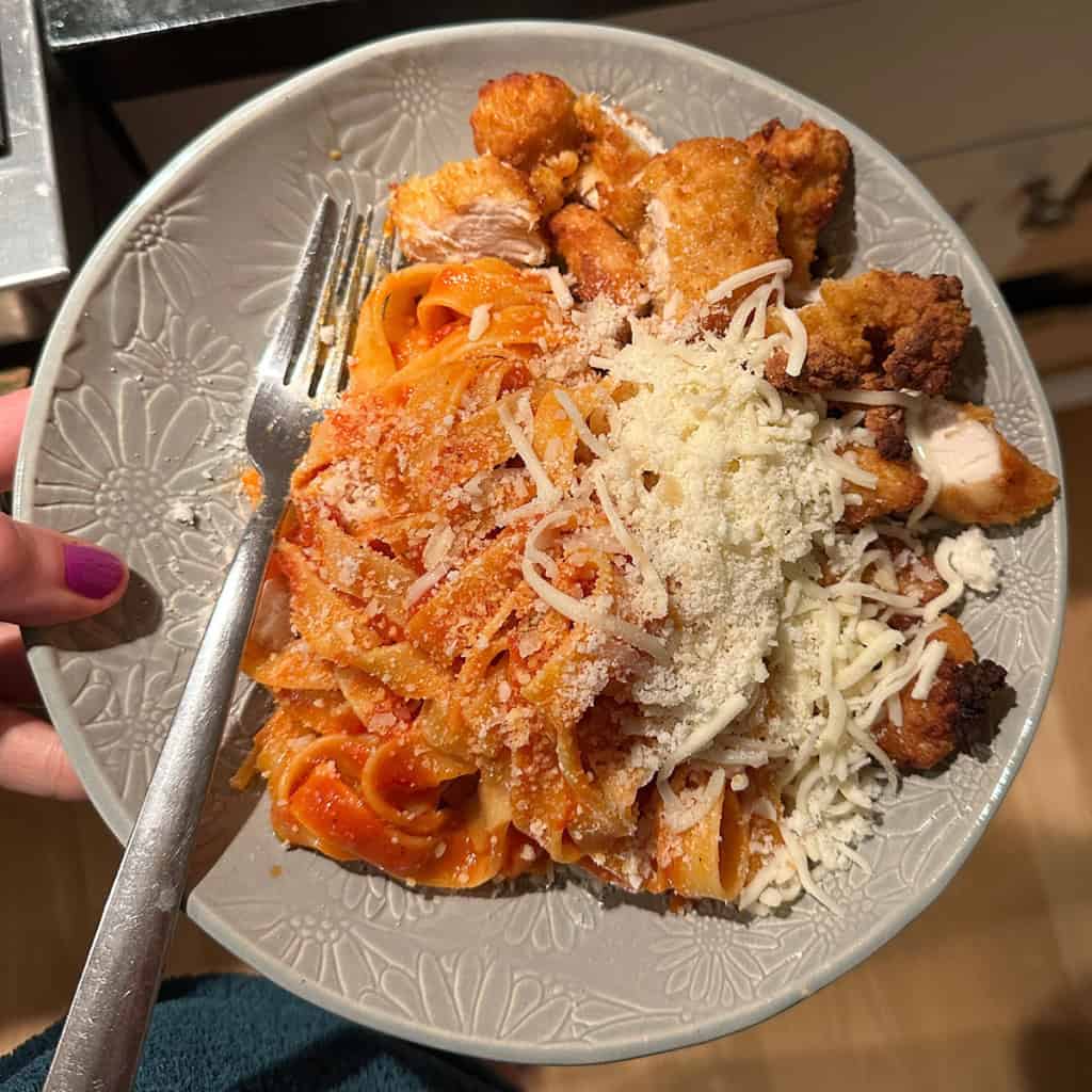 pasta and chicken on gray plate.