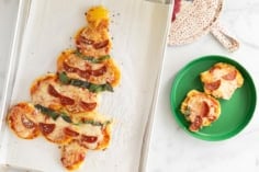 Christmas pizza on baking sheet and plates.