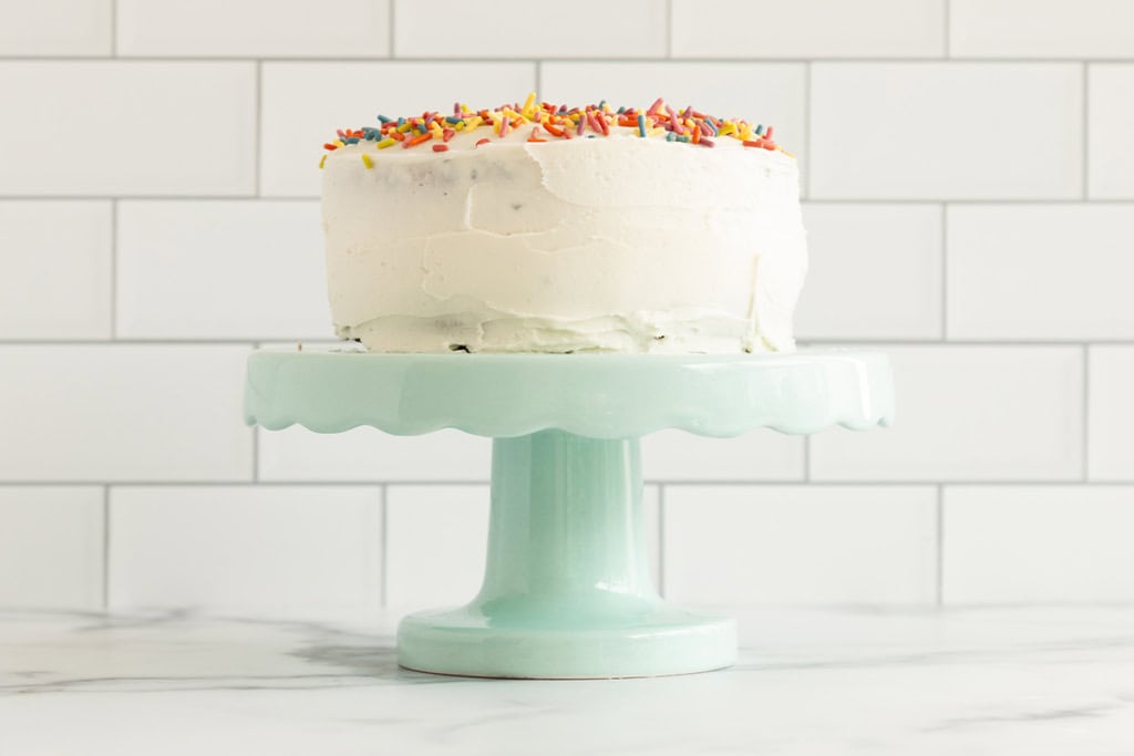 Finished funfetti cake on blue cake stand.