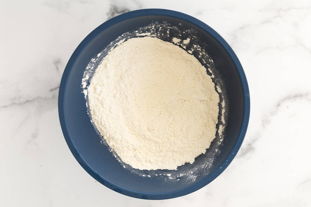 Dry ingredients for funfetti cake in blue bowl.