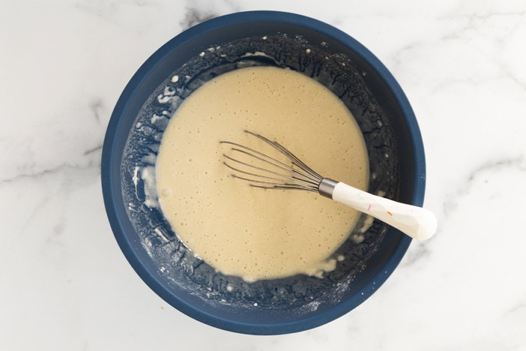 wet ingredients for funfetti cake in blue bowl.