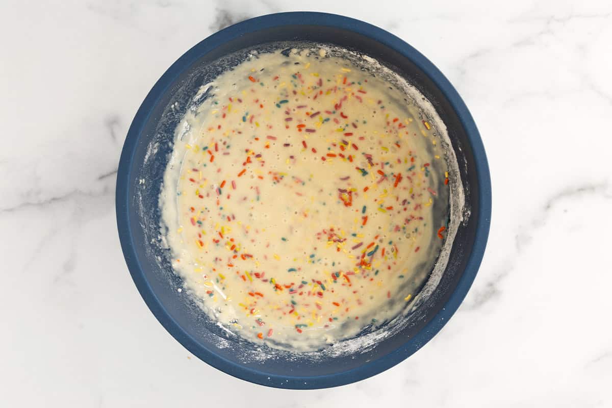 Batter for funfetti cake in blue bowl.