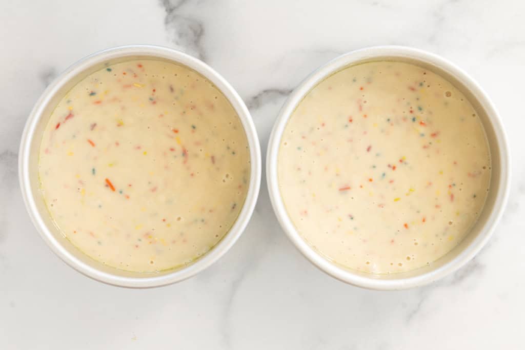 Funfetti cake in two cake pans before baking.