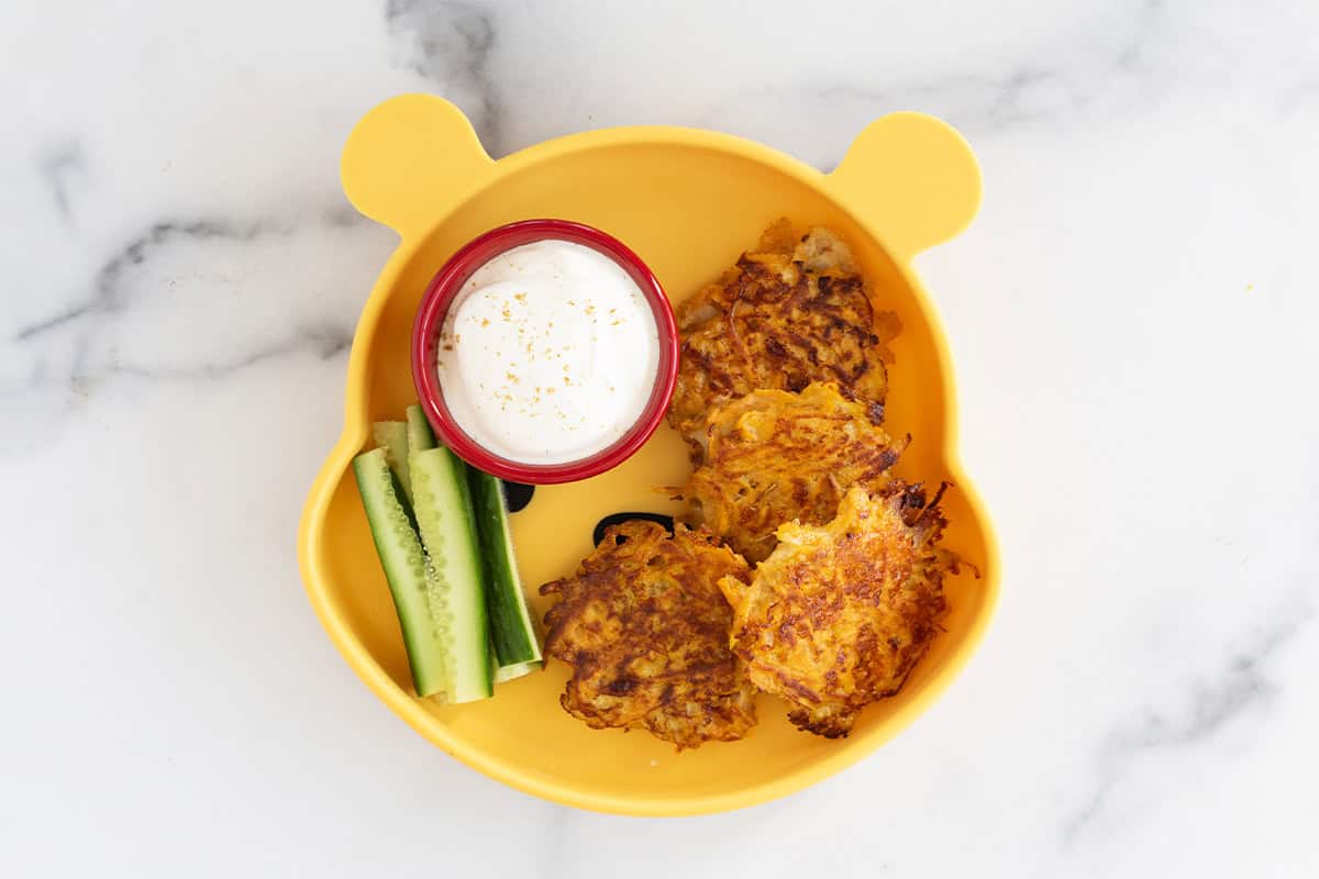 Sweet potato fritters on pooh plate with dip.