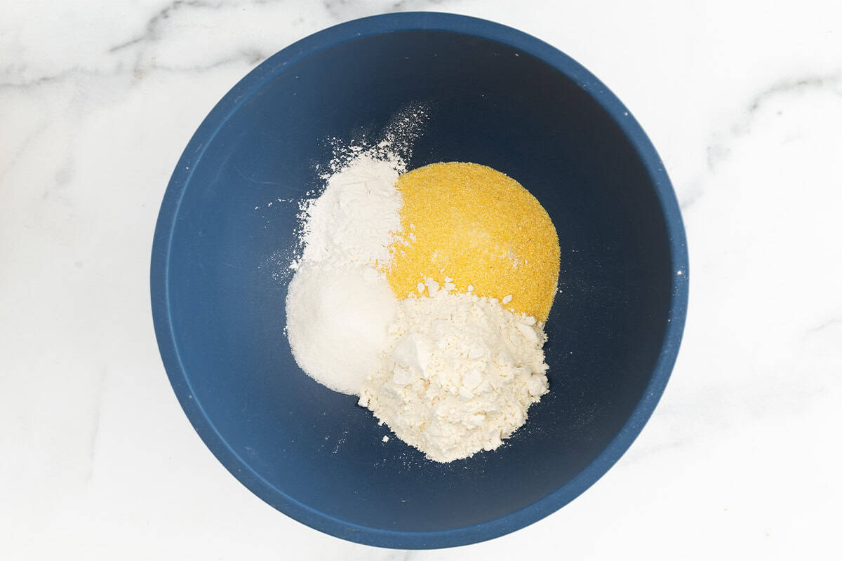 Ingredients for cornmeal pancakes in bowl before mixing.