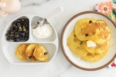 Cornmeal pancakes on two plates.