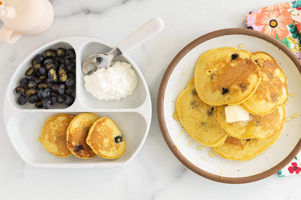 Cornmeal pancakes on two plates. 