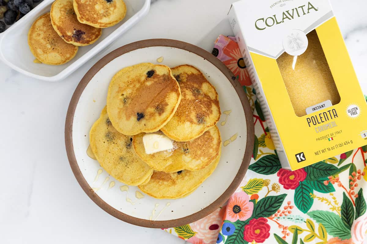 Cornmeal pancakes on plate with polenta on side.