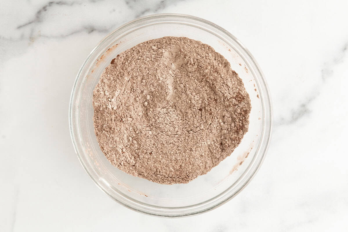 Dry ingredients for double chocolate muffins in glass bowl.