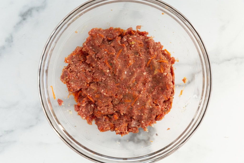 Mixture for mini meatloaves in glass bowl.