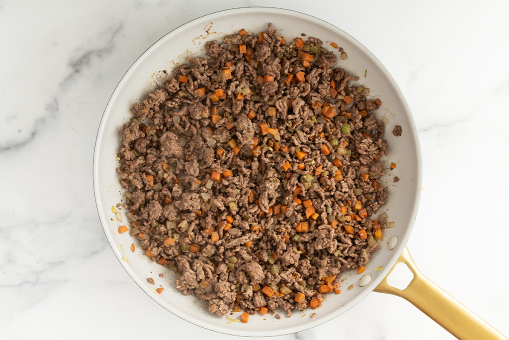 Ground beef and vegetables in frying pan for baby bolognese.