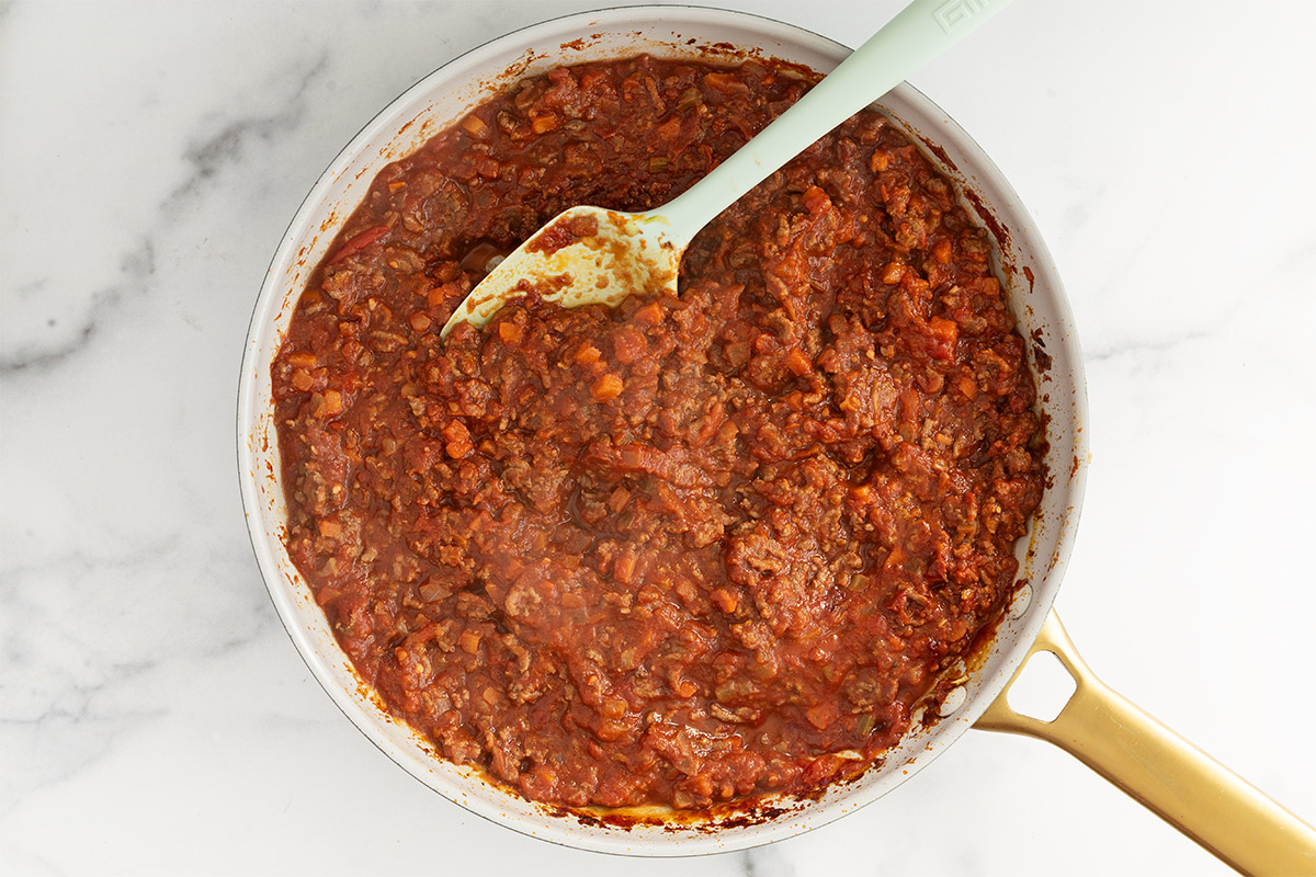 baby bolognese in frying pan with spoon.