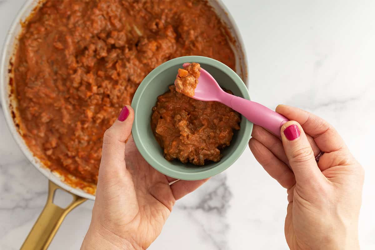 baby bolognese in bowl with spoon.