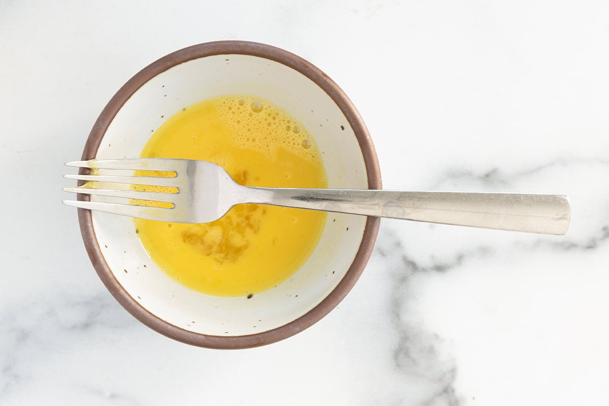 Egg in bowl with fork for baby omelette.