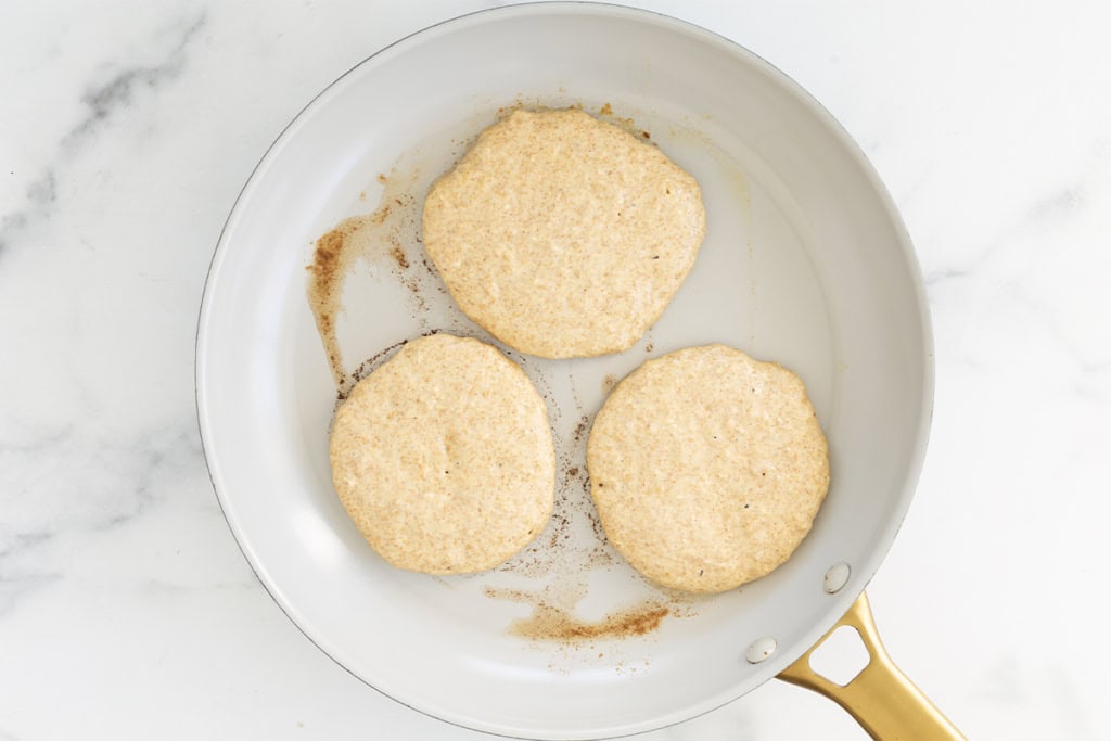 Oatmeal protein pancakes in pan before flipping.