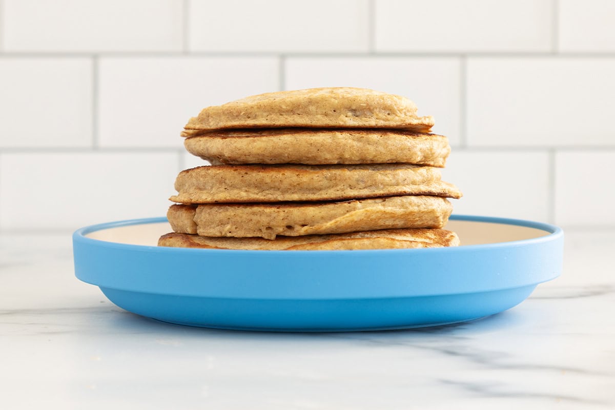 Stack of oatmeal protein pancakes on blue plate.