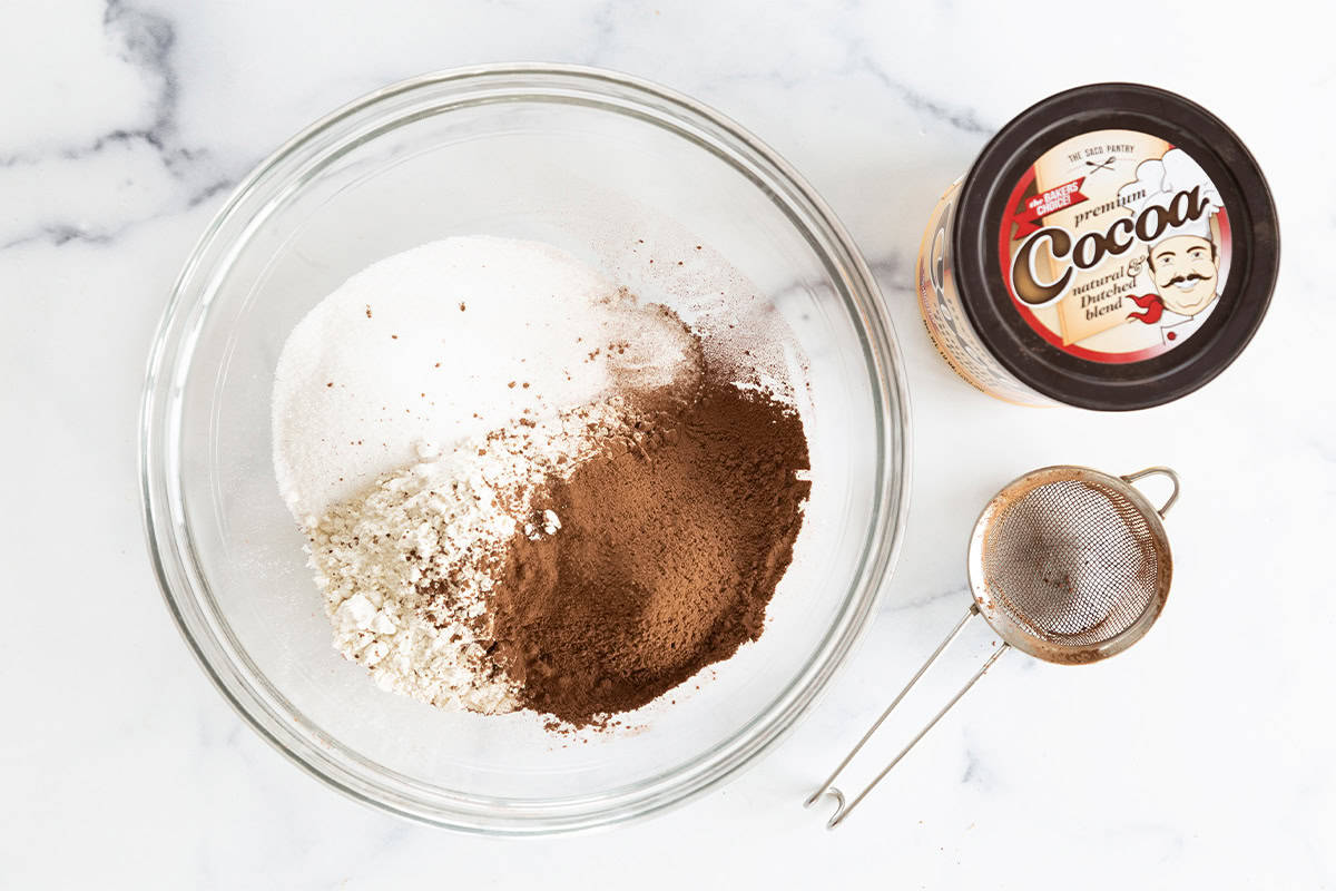 Ingredients for vegan chocolate cupcakes in glass bowl before mixing. 