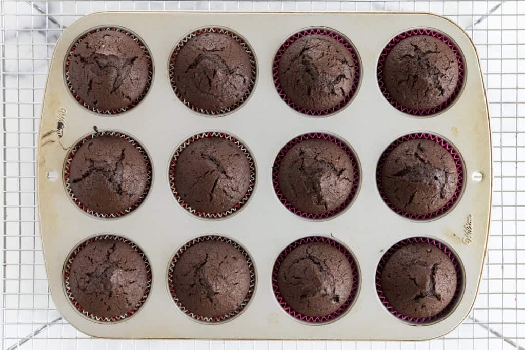 Vegan chocolate cupcakes in muffin pan after baking.