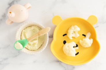 Cauliflower baby food in bowl and on kids plate.