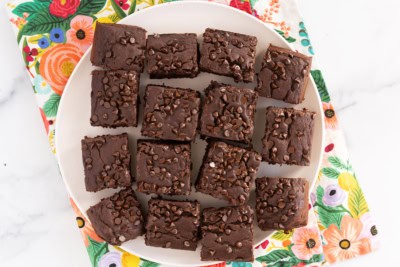 Chocolate snack cake cut into squares on plate.