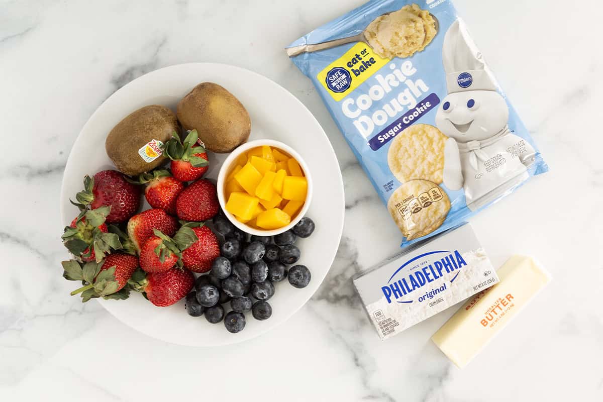 Ingredients for fruit pizza on countertop.