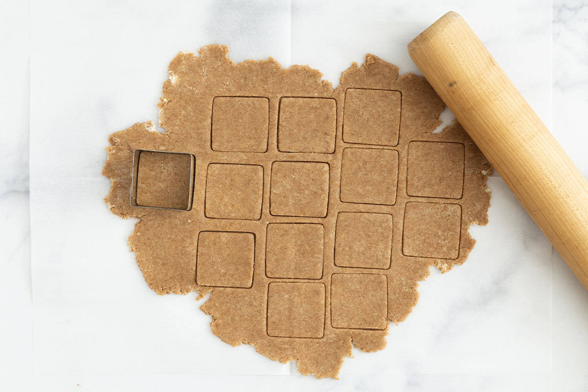 Dough for graham crackers rolled out and cut into squares.